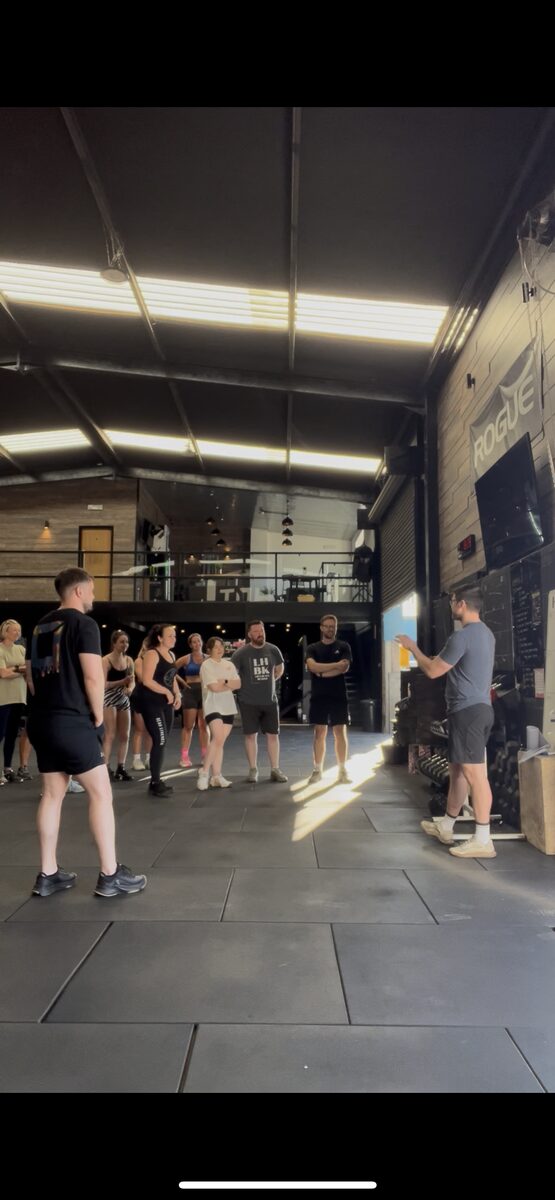 Liam Burke leading an in-person mobility class with a small group